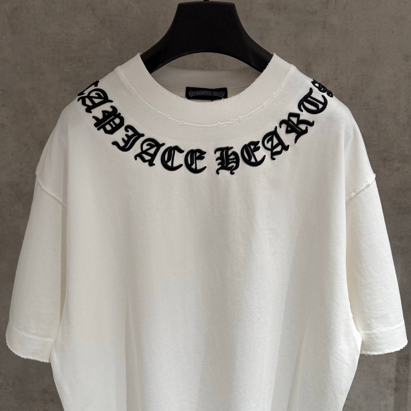 White short-sleeve T-shirt with bold black chest lettering graphic
