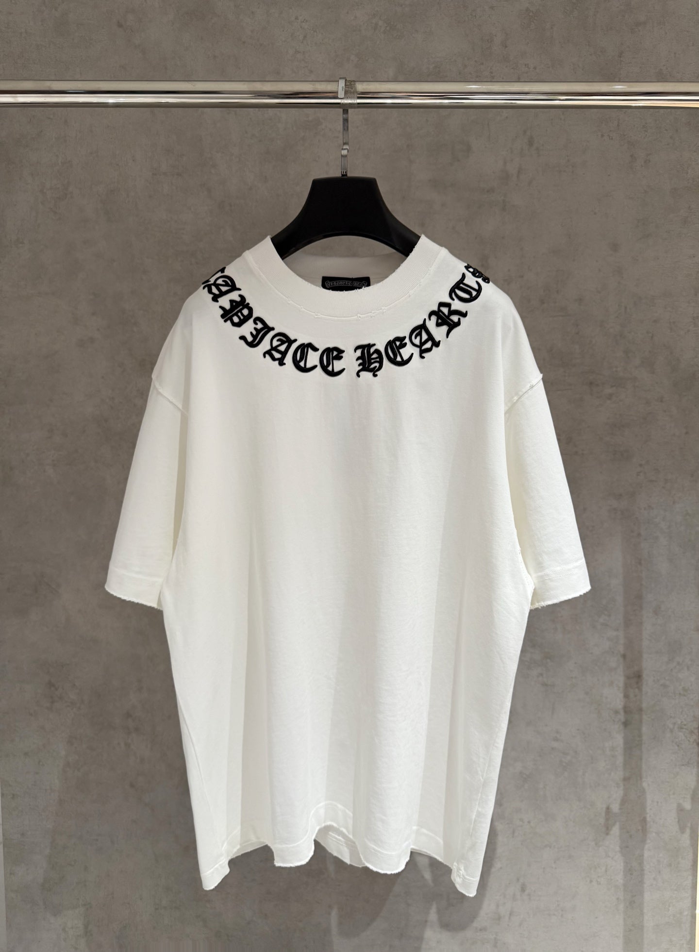 White short-sleeve T-shirt with black stylized chest graphic and crew neck