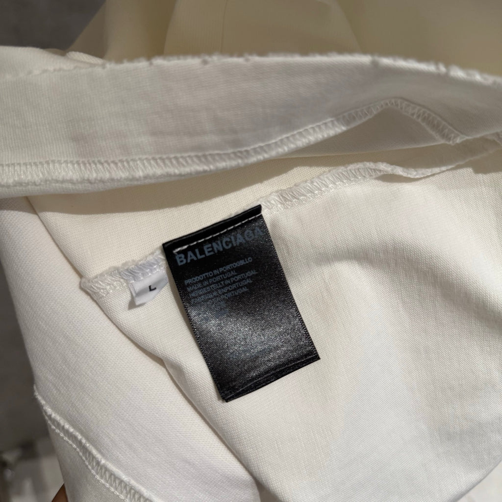White T-shirt hem with stitched edge and BALENCIAGA care tag