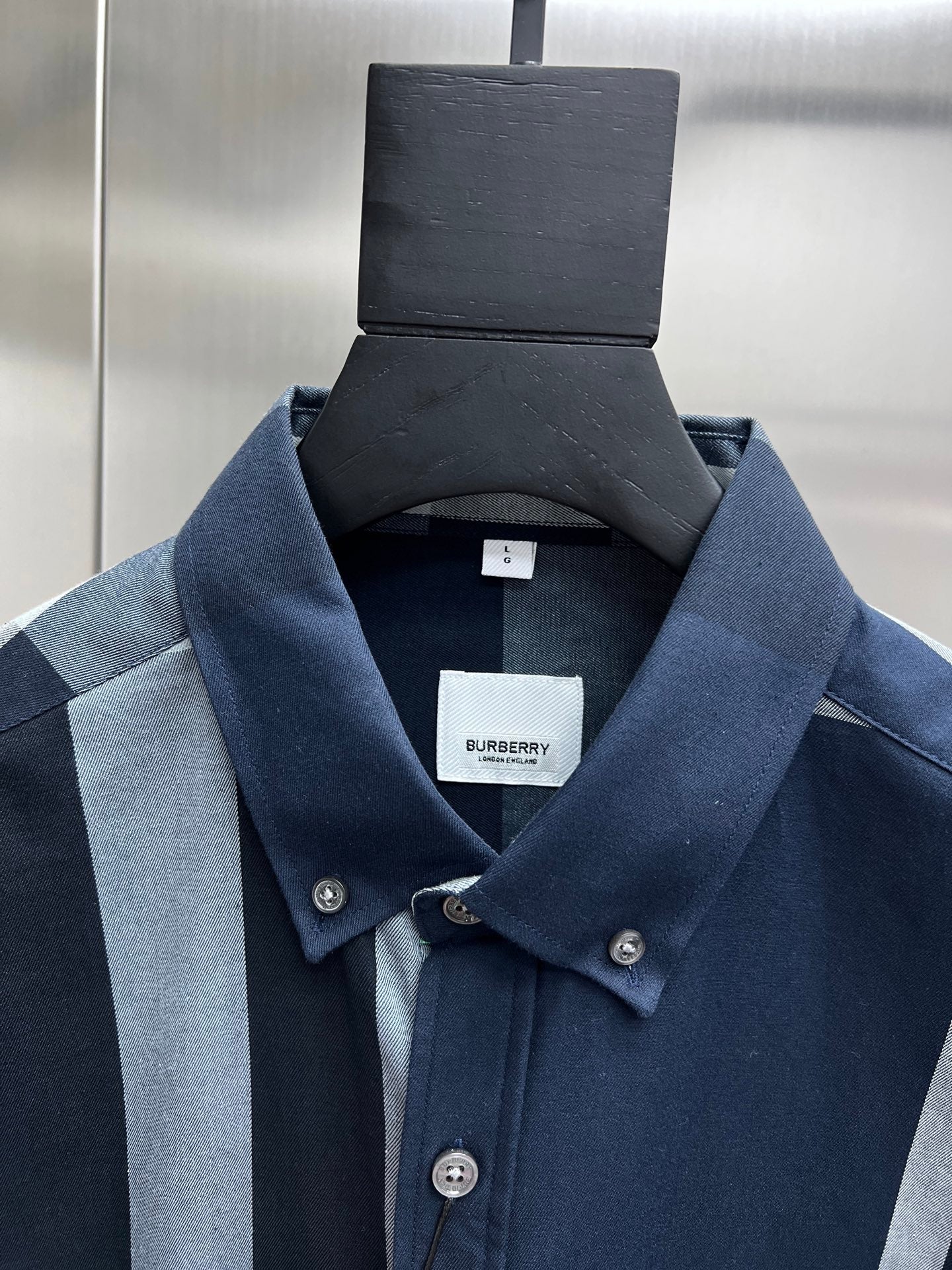 Navy long-sleeve button-up shirt with pointed collar and small chest fabric tag