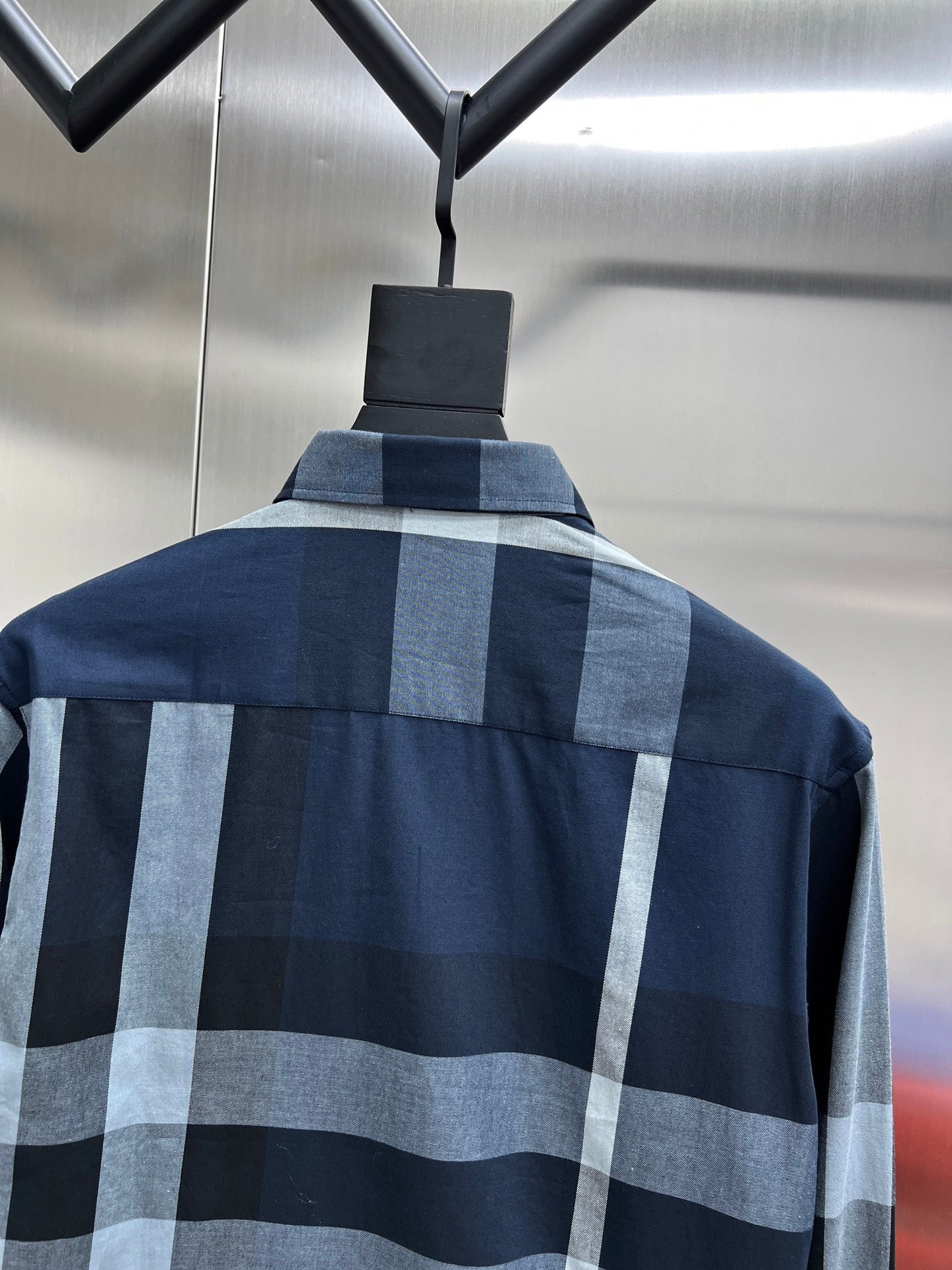 Navy long-sleeve plaid shirt with light blue and gray check pattern and stand collar