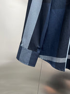 Long-sleeve cuff of navy plaid button-up shirt with light-blue striped panel