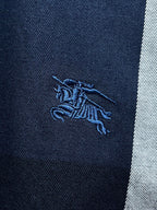 Embroidered horse logo on navy fabric of a plaid button-up shirt