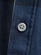 Close-up of button and placket on navy plaid long-sleeve shirt