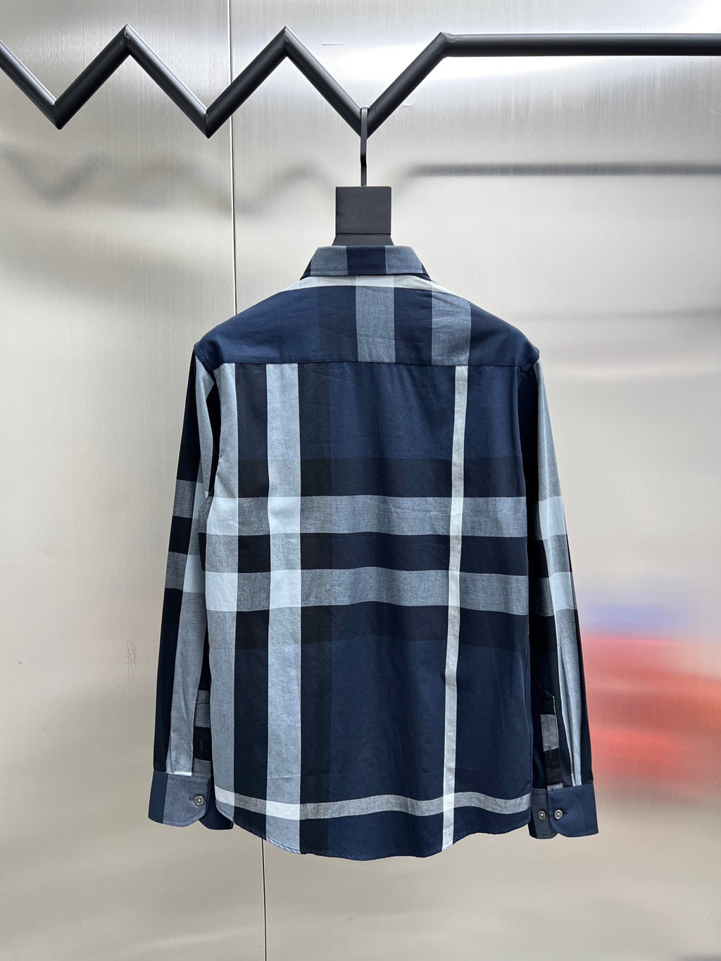 Back view of navy plaid long-sleeve button-up shirt with pointed collar and yoke seams