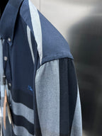Shoulder and sleeve of navy plaid button-up shirt with light-blue vertical panel
