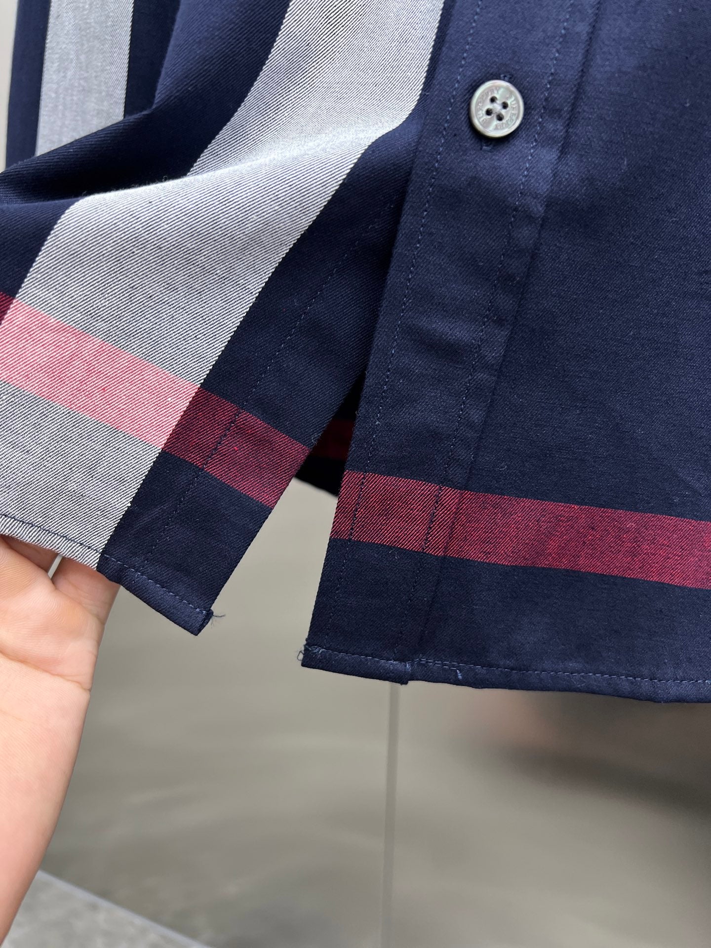 Long-sleeve check shirt cuff with two buttons and navy, gray, red stripe panels