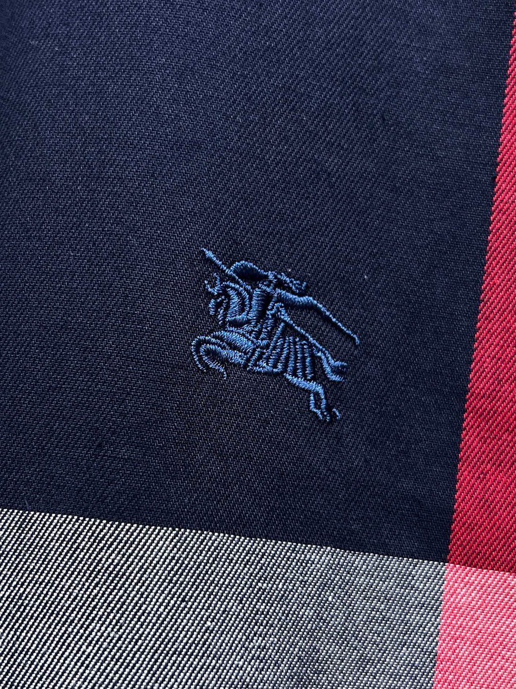 Embroidered horse logo on navy plaid long-sleeve shirt with red stripe
