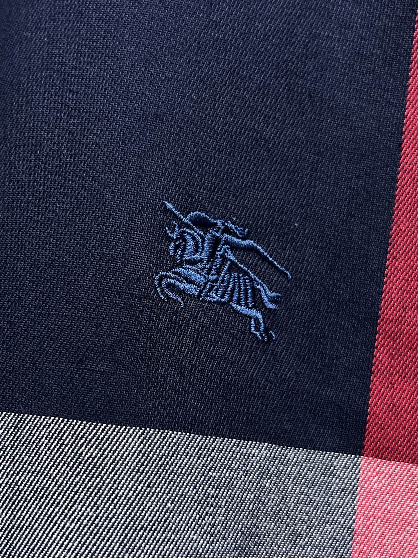 Embroidered horse logo on navy plaid long-sleeve shirt with red stripe
