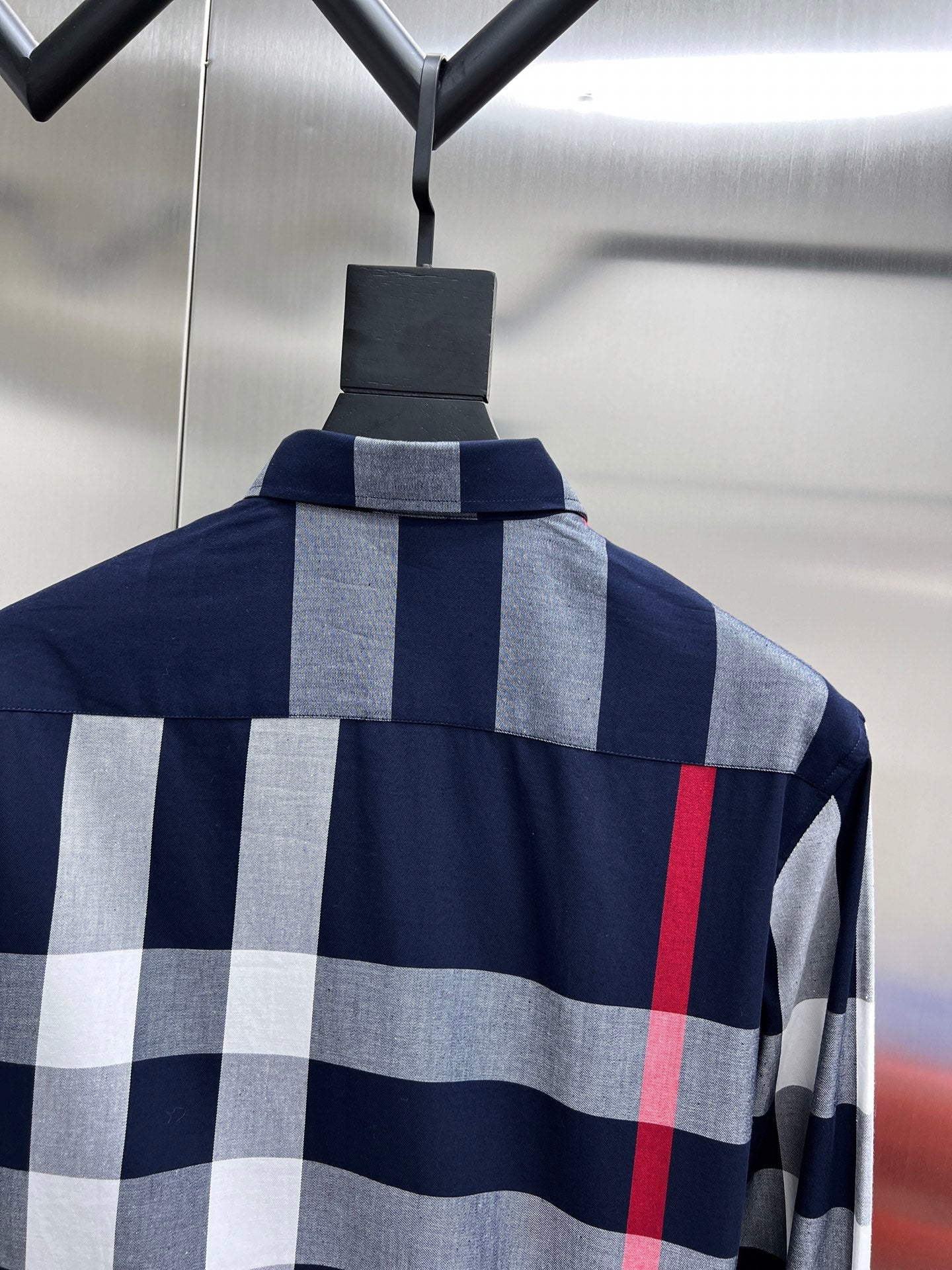 Back view of check long-sleeve shirt on hanger, navy with gray squares and red stripe