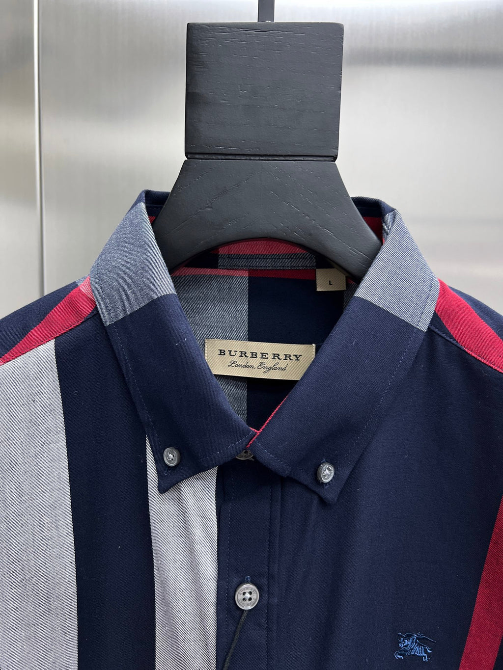 Long-sleeve plaid shirt neckline and front placket, navy and white with red accents