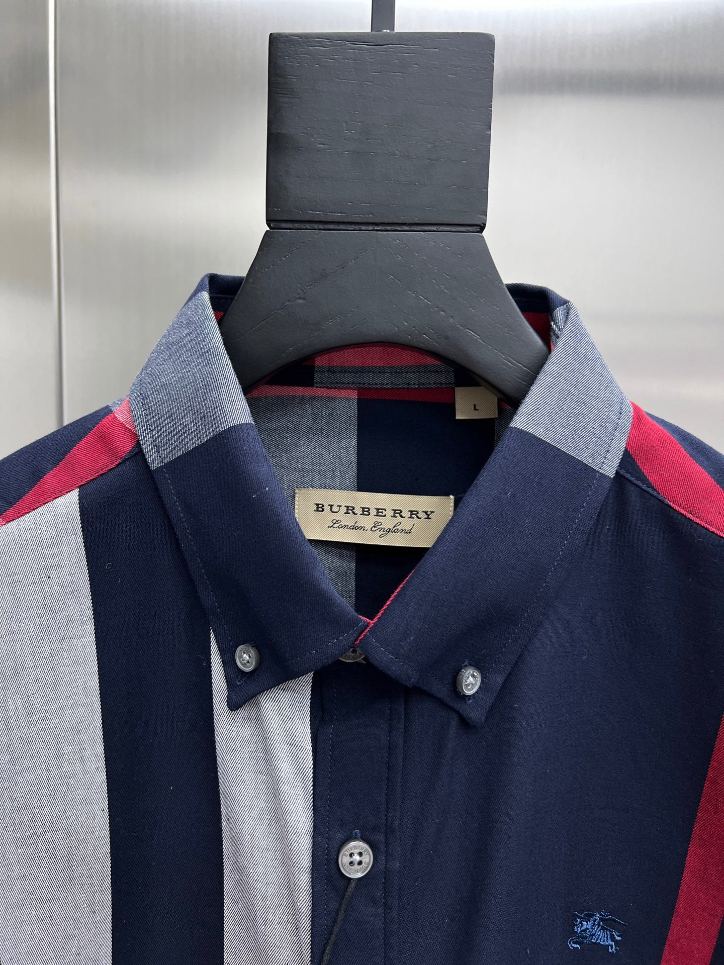 Long-sleeve plaid shirt neckline and front placket, navy and white with red accents