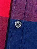 Button detail on plaid long-sleeve shirt in blue, red, and purple check panels