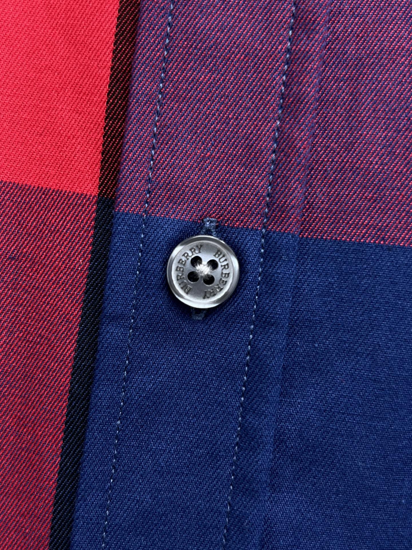 Button detail on plaid long-sleeve shirt in blue, red, and purple check panels
