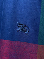 Embroidered Burberry horse logo on blue plaid fabric with purple and red bands