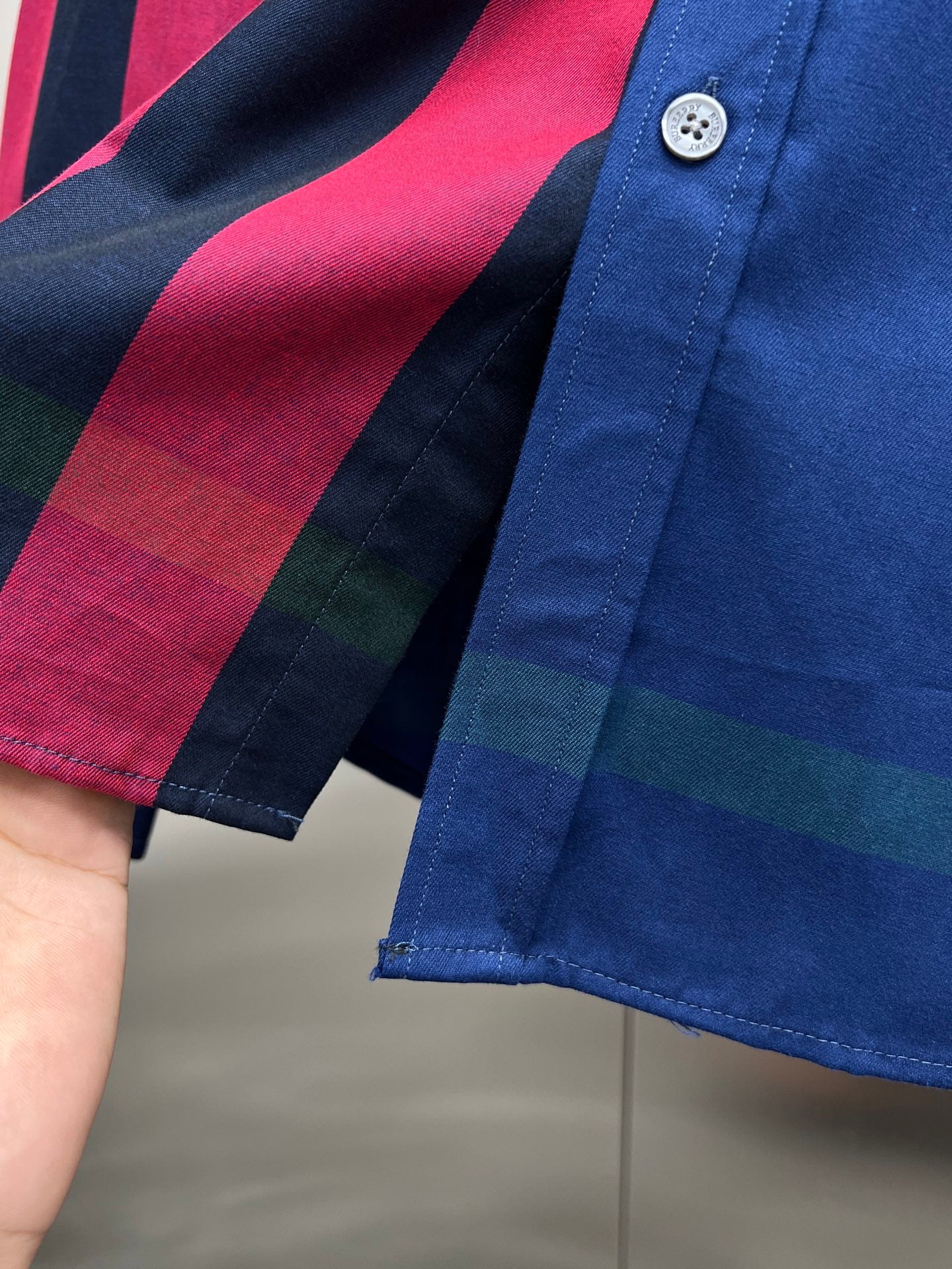 Blue long-sleeve button-up shirt with multicolor plaid pattern and white buttons