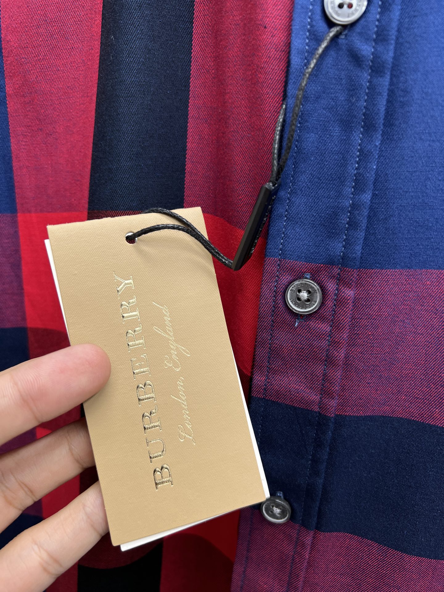 Hanging price tag and plaid long-sleeve button-up shirt with blue and red checks