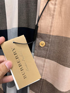 Burberry paper hang tag on plaid button-up shirt with gold button