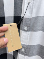 Long-sleeve button-up shirt with tan hang tag on white and gray plaid.