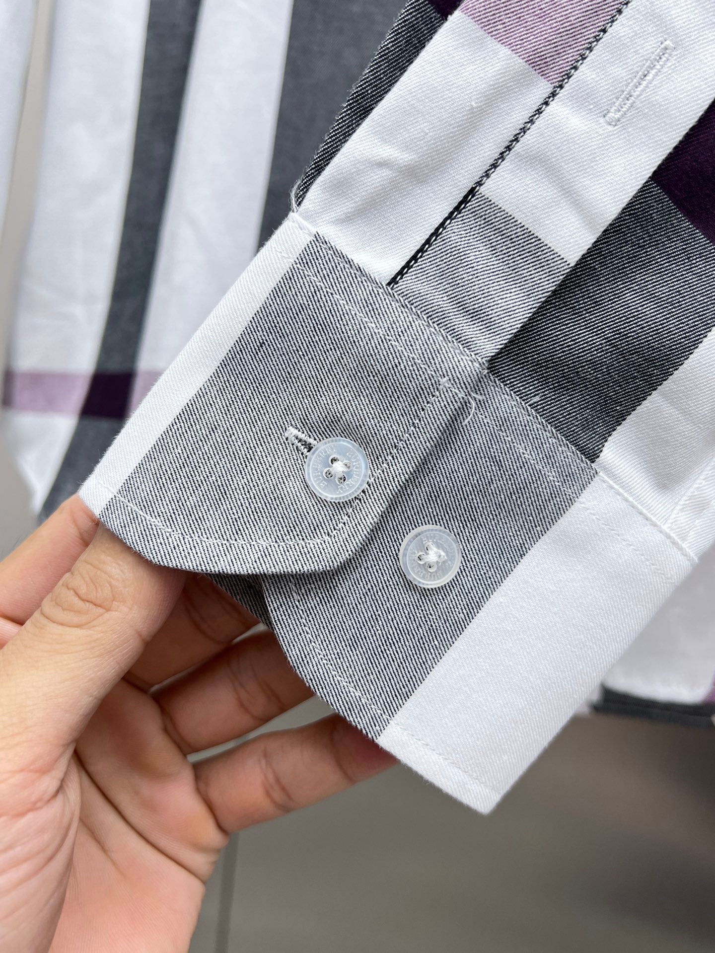 Long-sleeve shirt cuff with two buttons, white, gray, and plum plaid trim