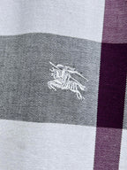 Embroidered horse logo on plaid fabric, gray and maroon stripe.