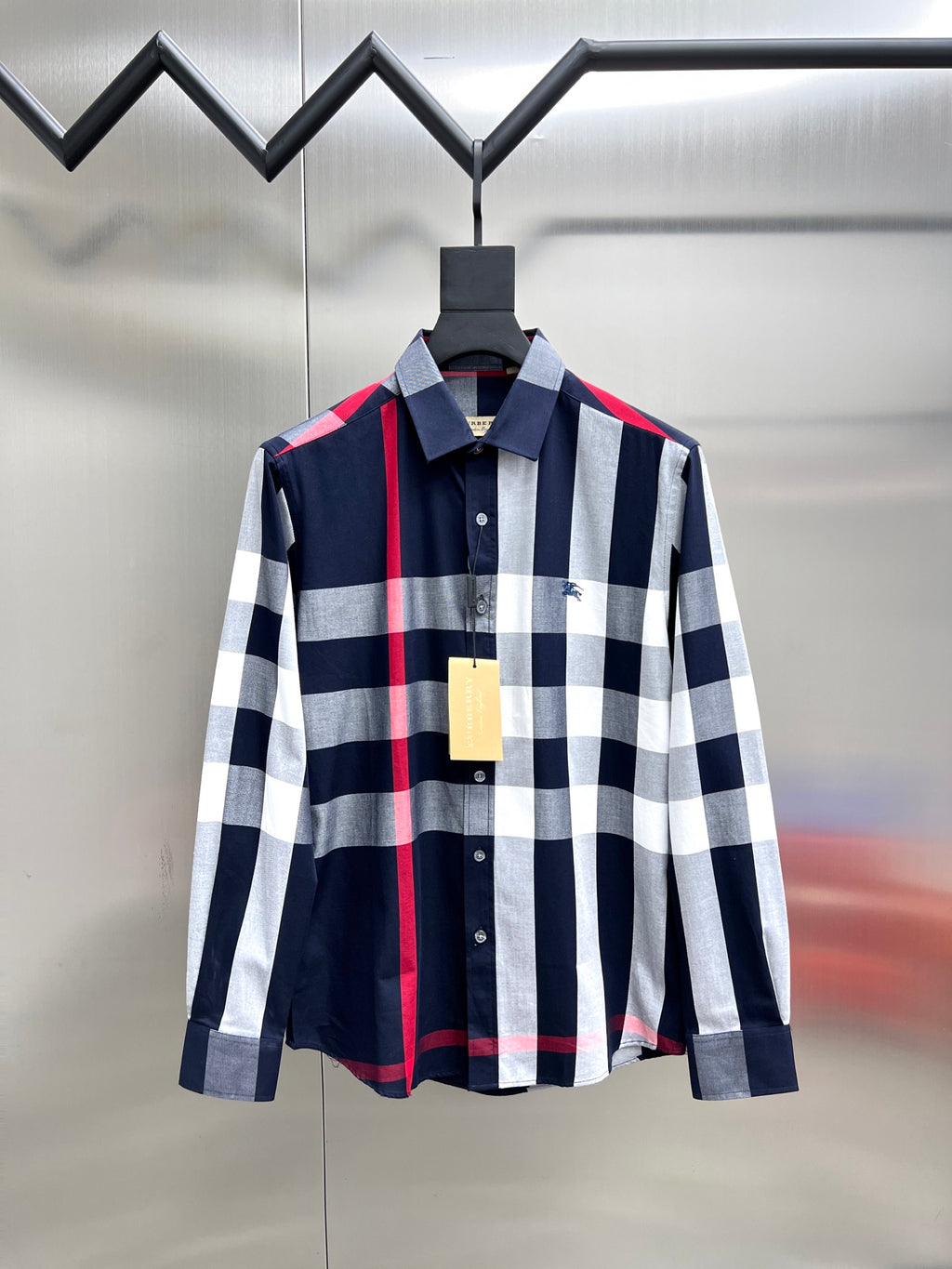 Long-sleeve button-up shirt in navy, white, and red plaid check