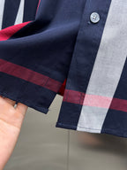 Long-sleeve plaid shirt cuff with buttons, navy, gray, and red check details