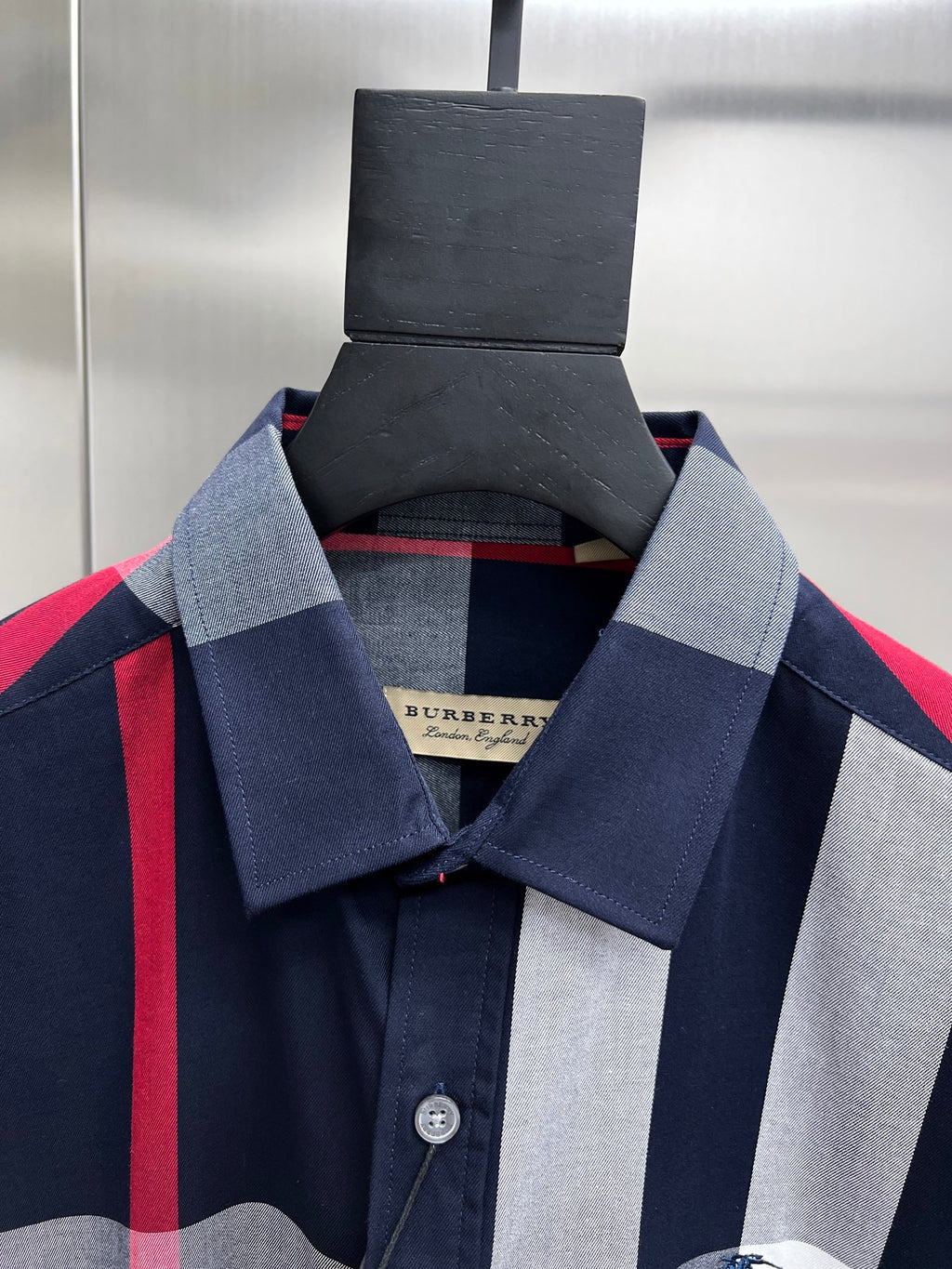 Collar and chest detail of plaid button-up shirt with navy and light gray
