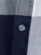 Close-up of button placket on navy-and-white plaid button-up shirt