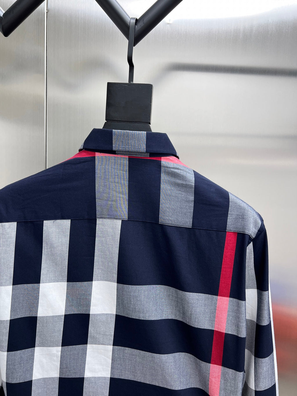 Plaid long-sleeve shirt on hanger, navy with gray and red check