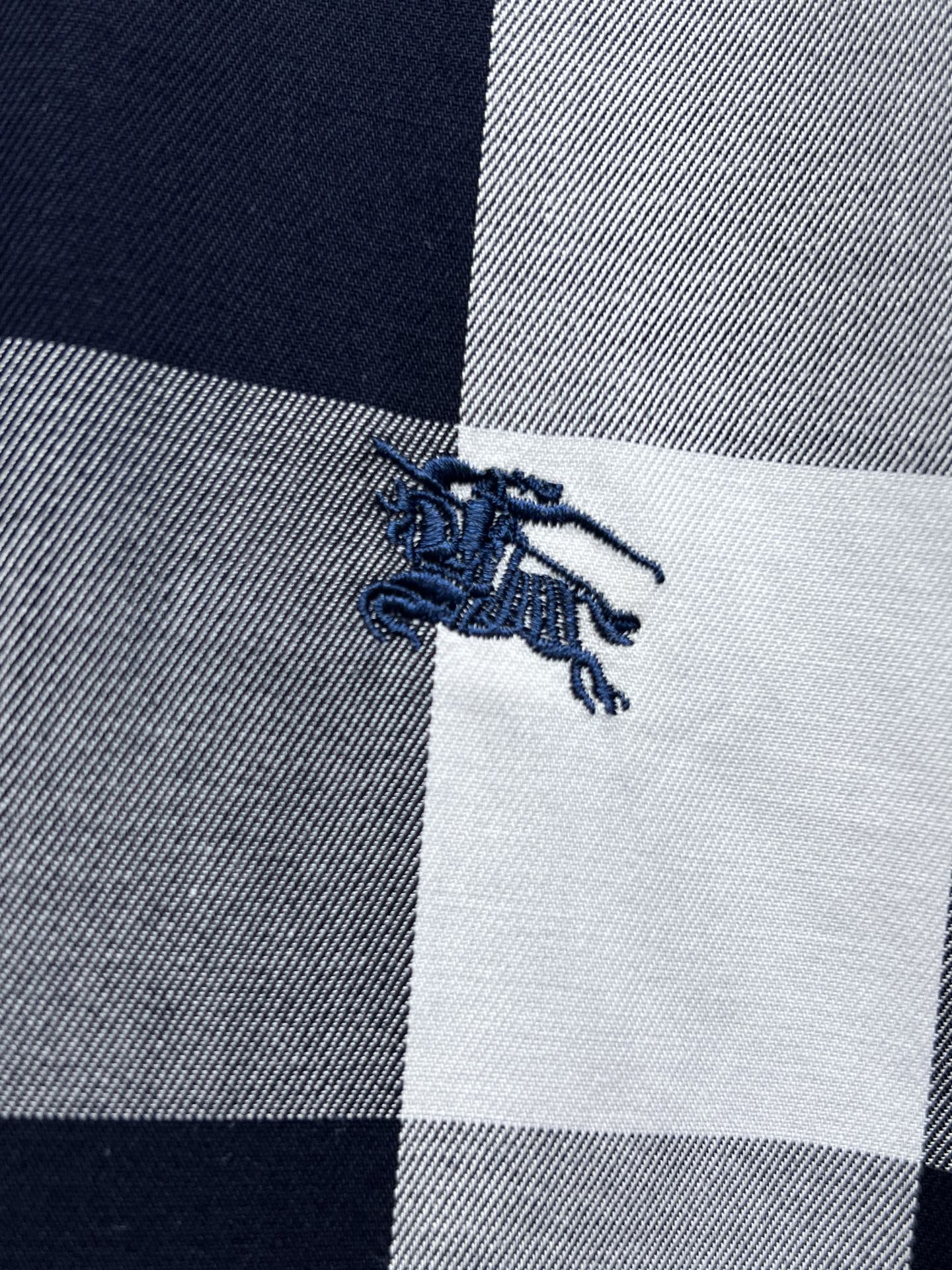 Embroidered horse logo on navy-and-white plaid fabric