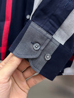 Plaid shirt cuff and button placket, navy with gray and red accents