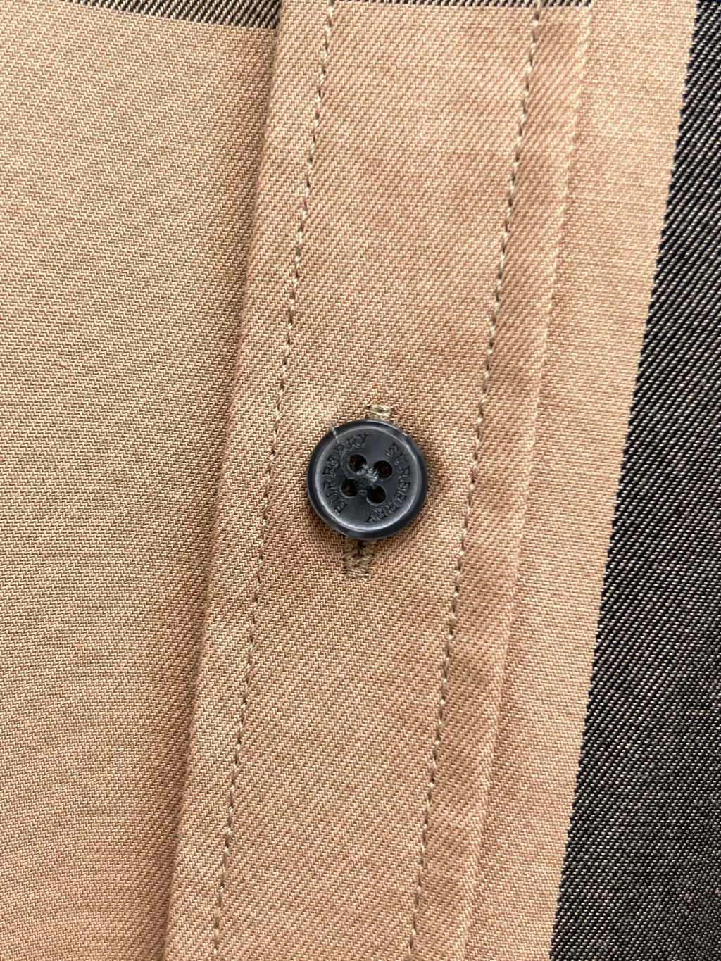 Beige plaid button placket with dark round button