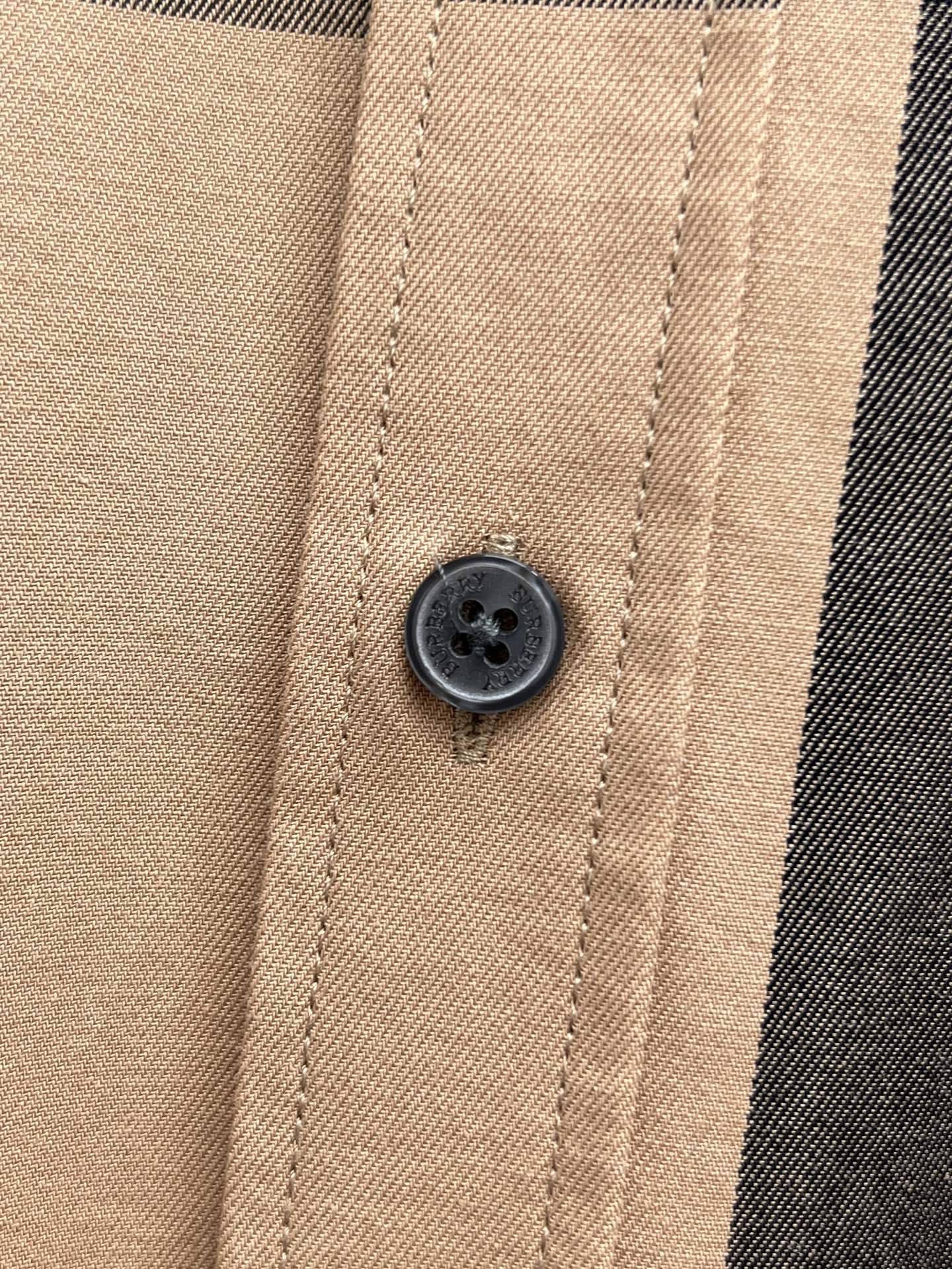 Beige plaid button placket with dark round button