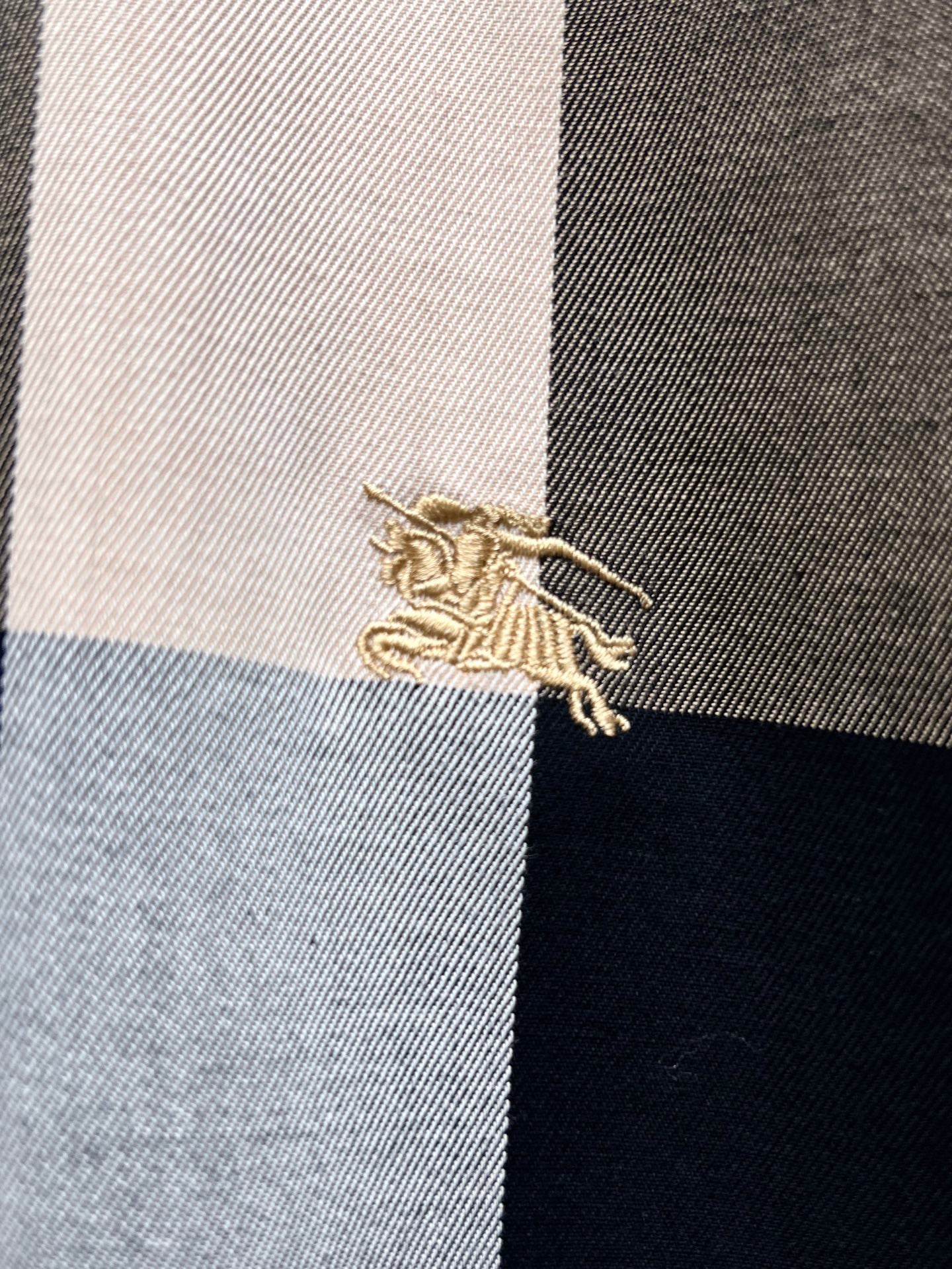 Embroidered Burberry logo on plaid fabric panel