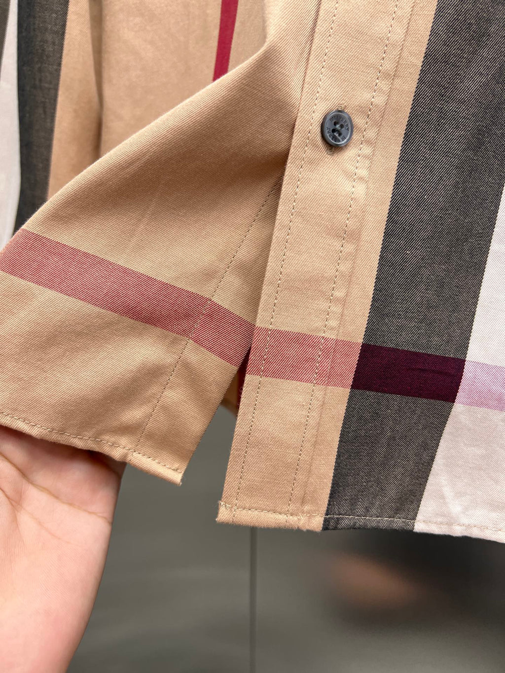 Beige long-sleeve shirt cuff with button and plaid check trim
