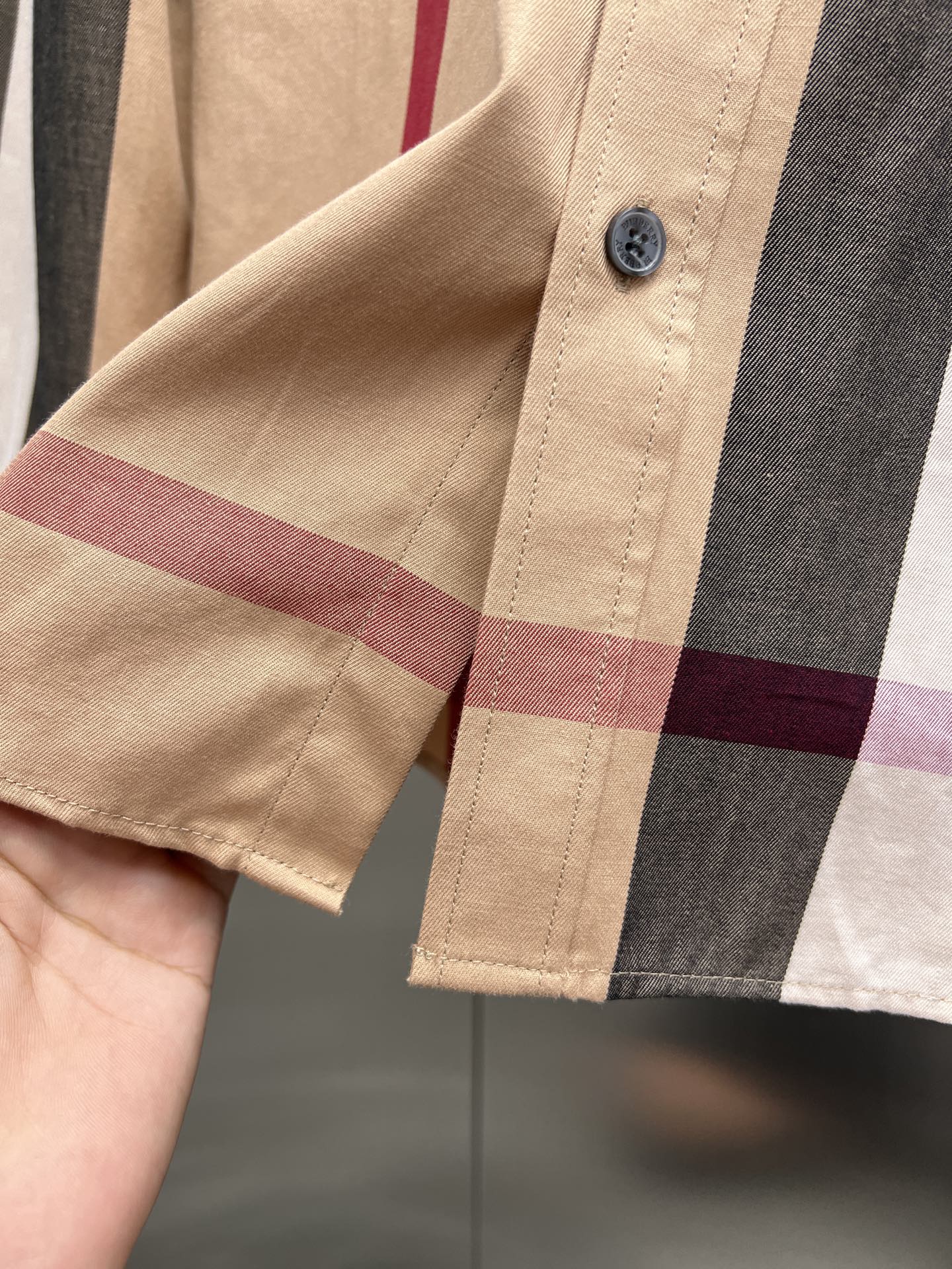 Beige long-sleeve shirt cuff with button and plaid check trim