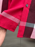 Long-sleeve shirt cuff with red plaid pattern and button detail