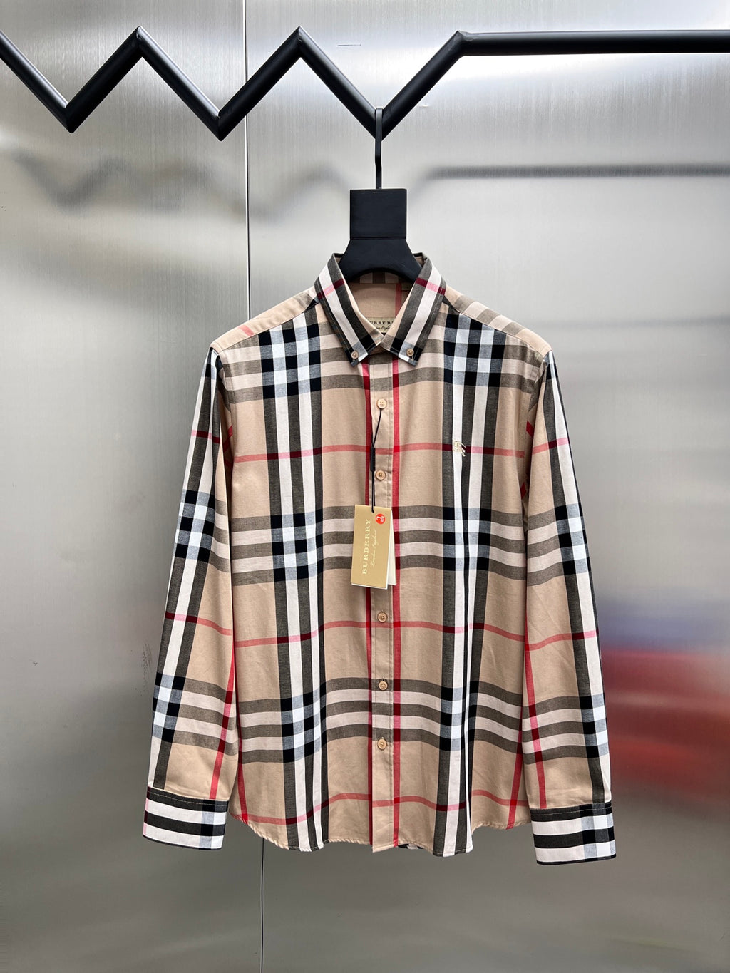 Plaid long-sleeve button-up shirt on hanger, beige with black and red stripes
