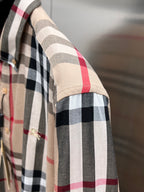 Side view close-up of plaid sleeve on beige button-up shirt with black and red