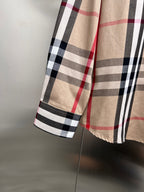 Lower sleeve and hem of plaid long-sleeve button-up shirt in beige, black, white, red