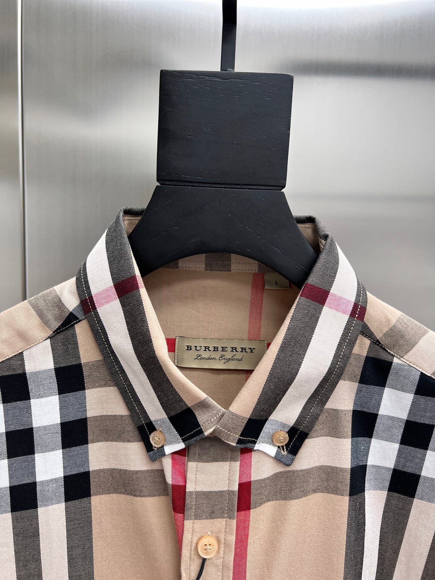 Plaid shirt neckline and buttons, beige fabric with black and red check pattern