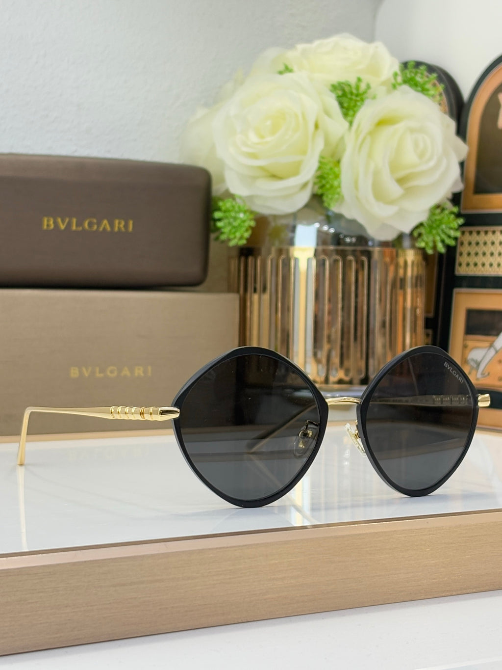 Black round sunglasses with dark lenses and gold-tone metal arms