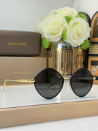 Black round sunglasses with dark lenses and gold-tone metal arms