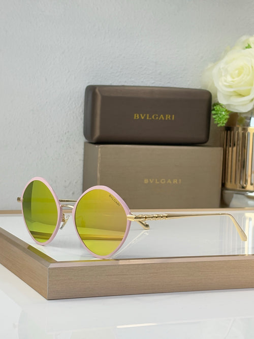 Round eyeglasses with gold frame, mirrored yellow lenses, and pink side accents