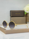 Gold round eyeglasses with dark tinted lenses and slim metal temples