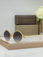 Gold round eyeglasses with dark tinted lenses and slim metal temples