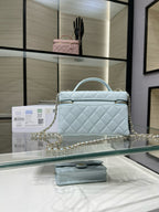 Light blue quilted handbag with gold chain shoulder strap and top handle