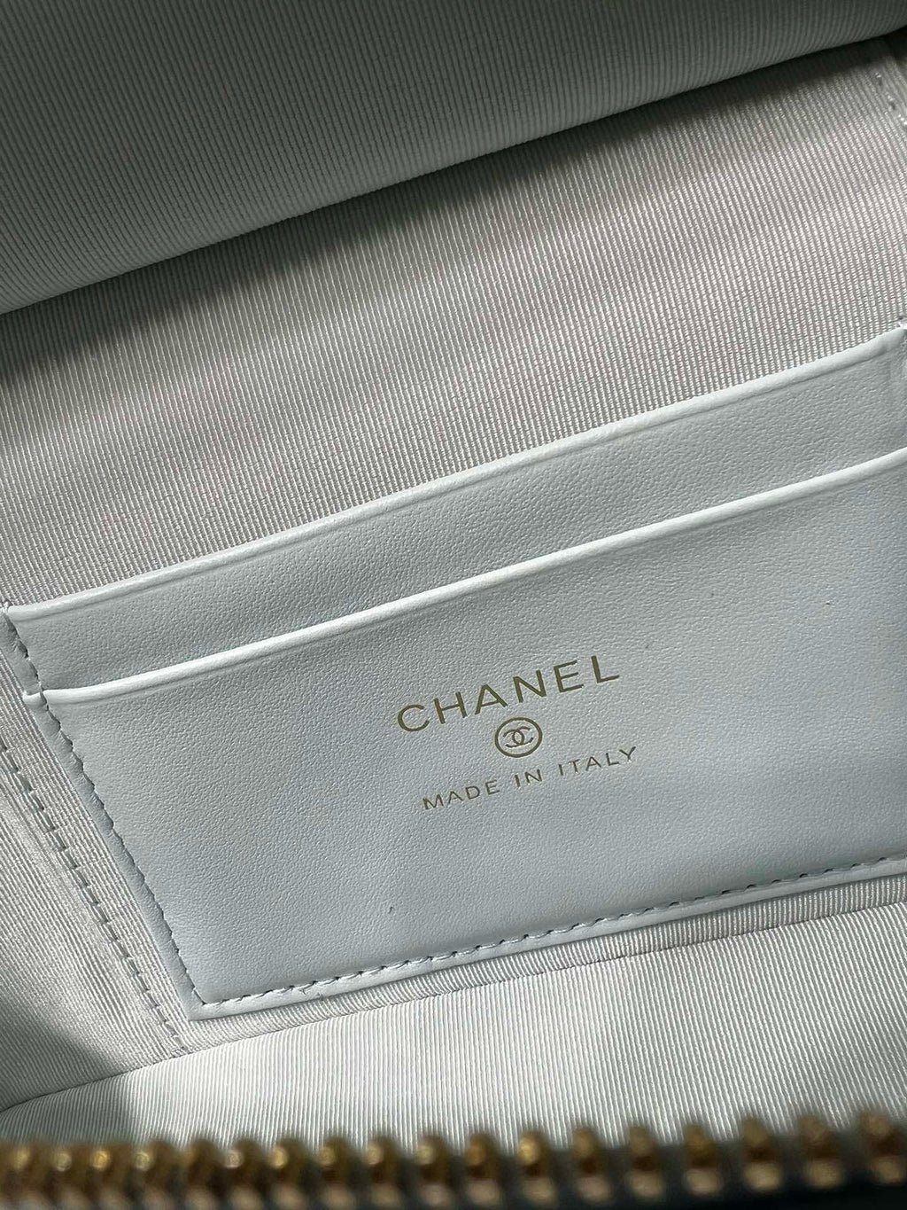 Light blue handbag inner label reading CHANEL and MADE IN ITALY