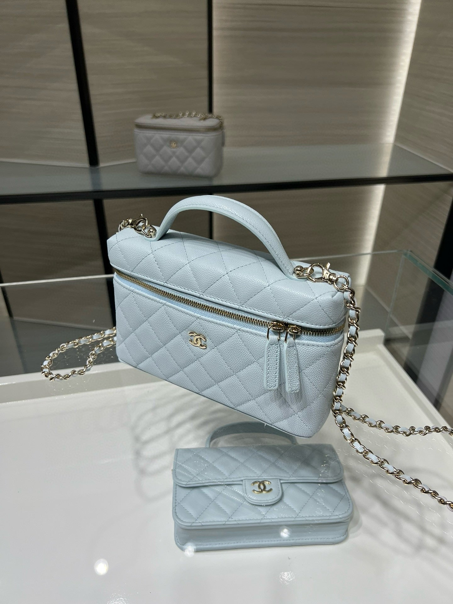 Light blue quilted handbag with gold chain strap and top handle, side view